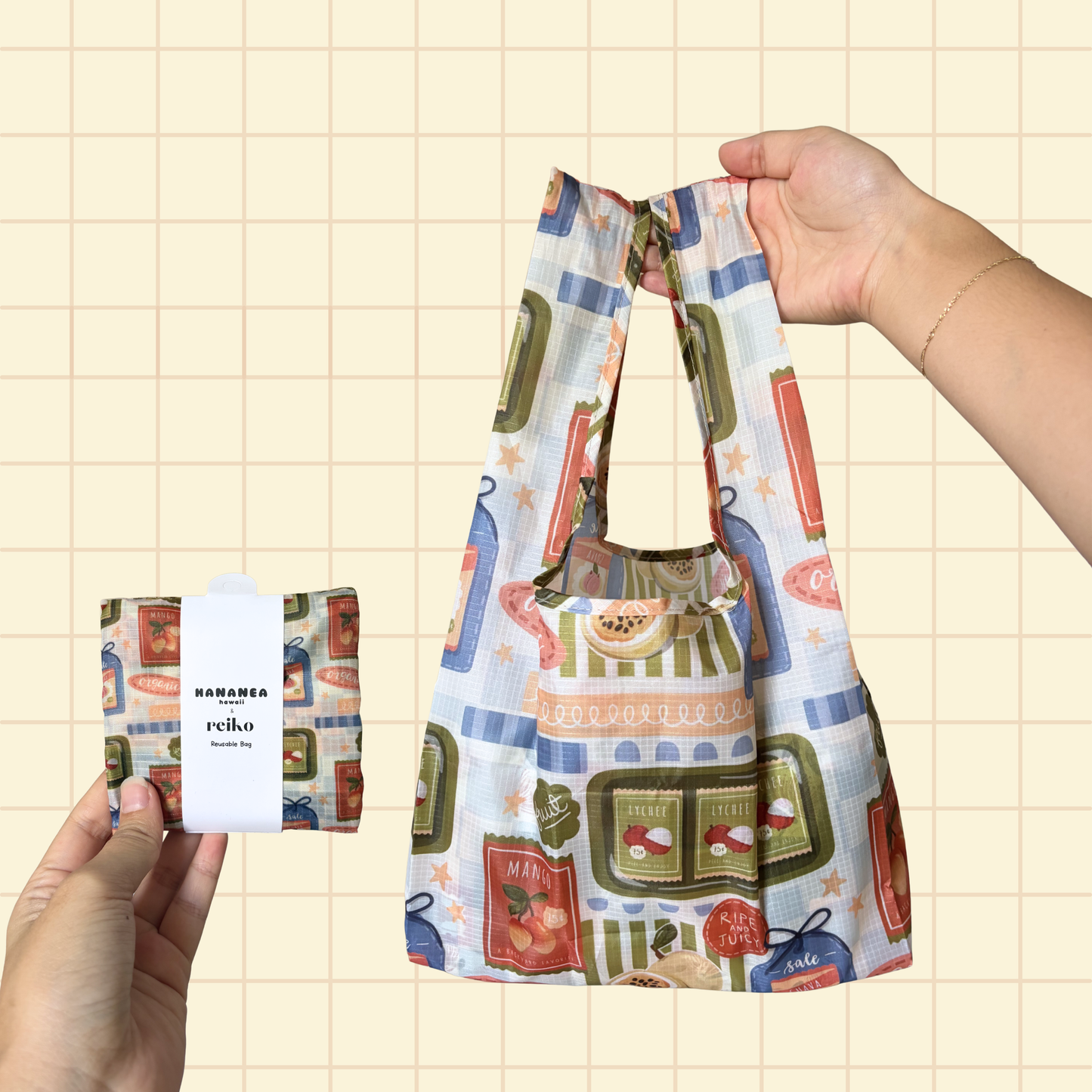 A reusable fabric shopping bag is held open by two hands against a pale beige grid background. The bag has long handles and a soft, flexible shape.
