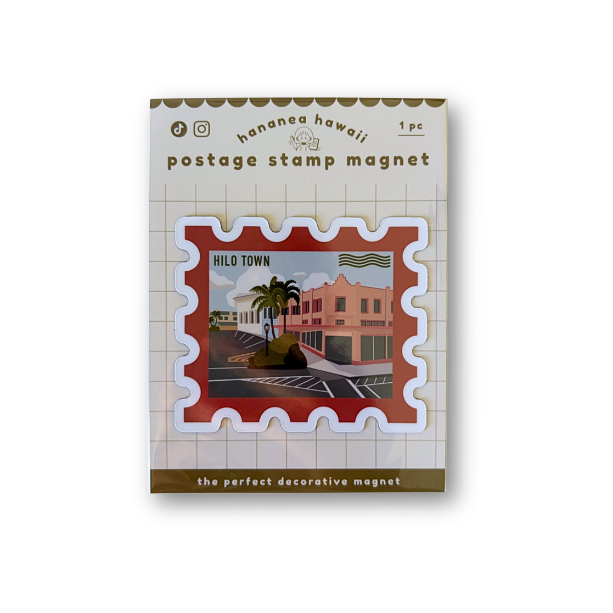 A postage stamp-shaped decorative magnet, featuring a red stamp border and a central illustrated scene of a tropical town with palm trees and buildings.