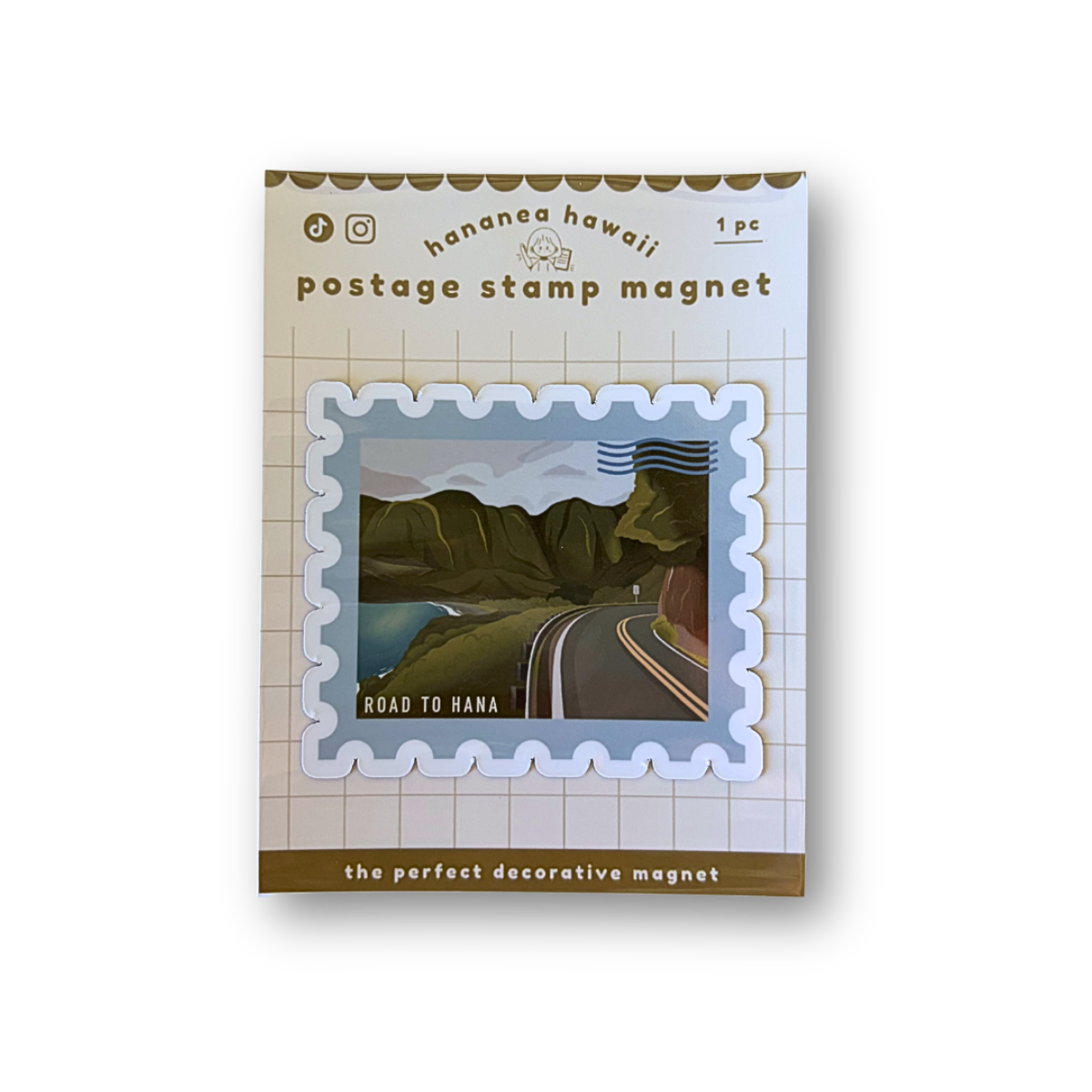 A postage stamp magnet product shown in its retail packaging on a plain white background. The package reads 'Hanananahawaii postage stamp magnet' and features a sample stamp design with a road through green hills under a blue sky.
