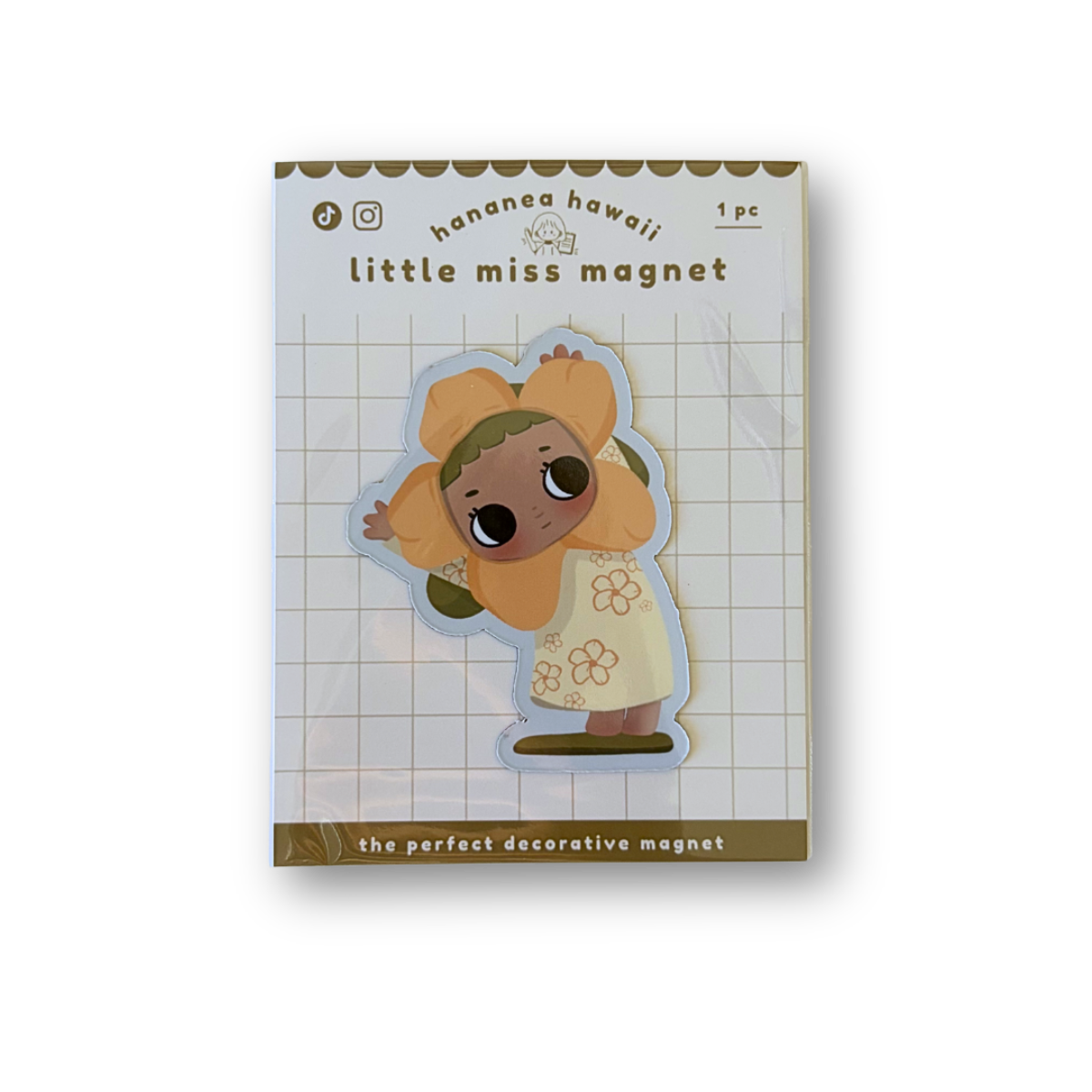 A packaged decorative magnet featuring a cute cartoon character in a yellow outfit on a white grid background.