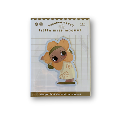 A packaged decorative magnet featuring a cute cartoon character in a yellow outfit on a white grid background.