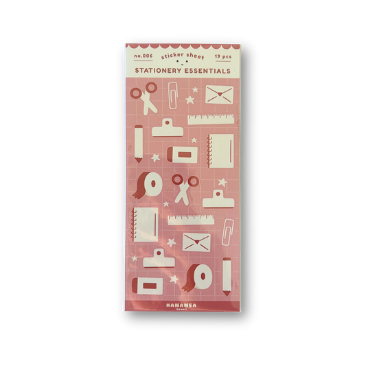 A tall, narrow package of  'Stationery Essentials' stickers, featuring a dusty pink background with cream-colored illustrations of office and desk items like pens, scissors, rulers, and envelopes.