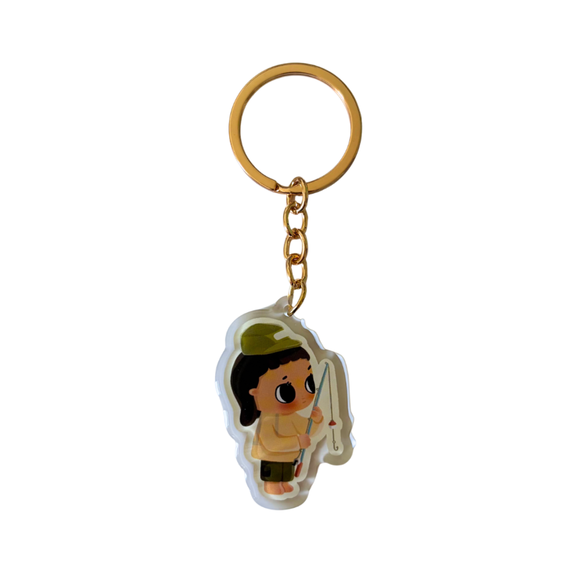 A gold-tone metal keychain with a small illustrated charm of a character holding a fishing rod, shown on a plain white background.