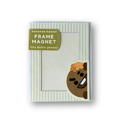 A frame magnet for picture frames, featuring a cartoon character peeking out from behind a striped cream frame, with a green label indicating it fits 2x3in photos.