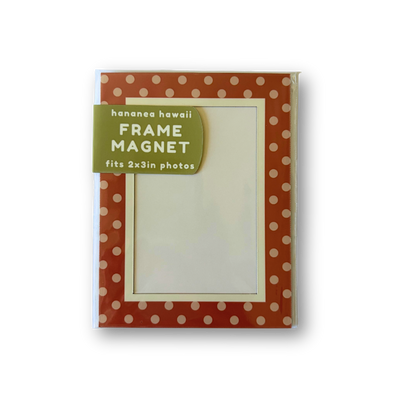 A packaged frame magnet with a rust-red border patterned with white polka dots and a green label.