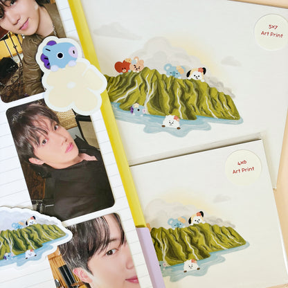 Art prints featuring cartoon animal illustrations on green hills, arranged on a beige background with some decorative paper and photo inserts.