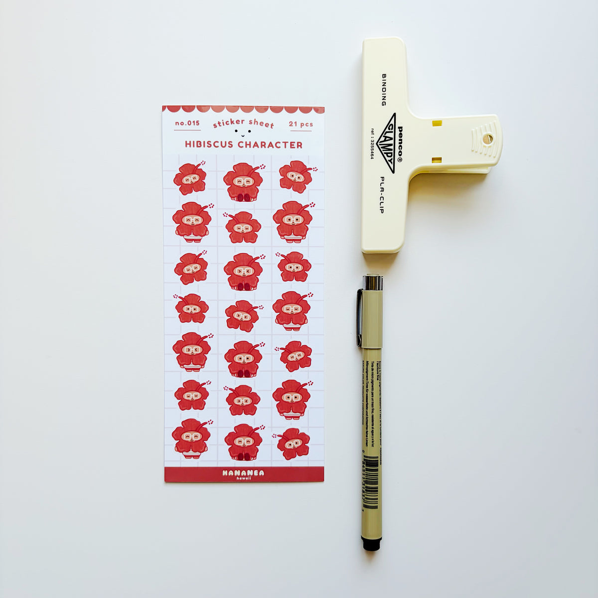 Red hibiscus sticker sheet with a brown pen and yellow clip on the side.