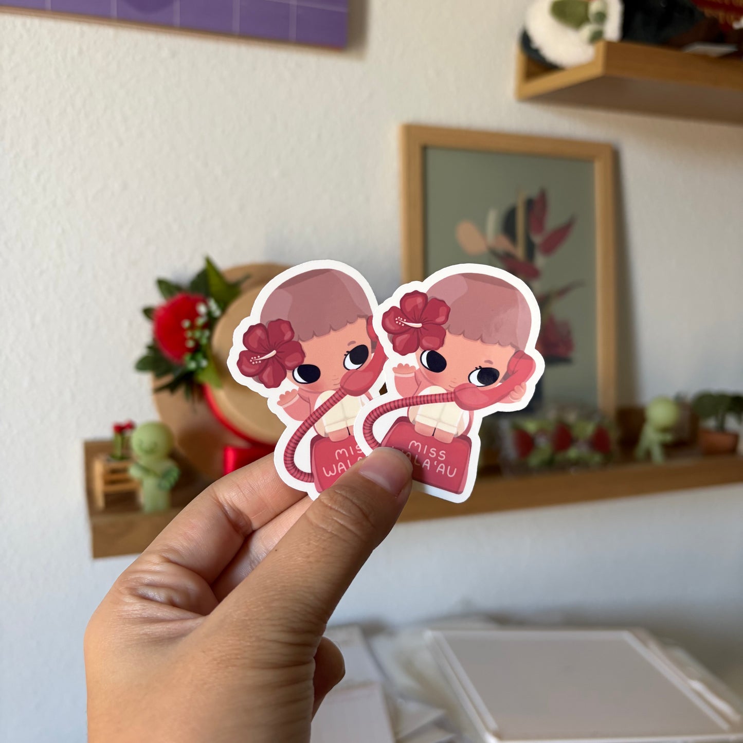 A hand holds two small die-cut stickers featuring a cute cartoon girl.