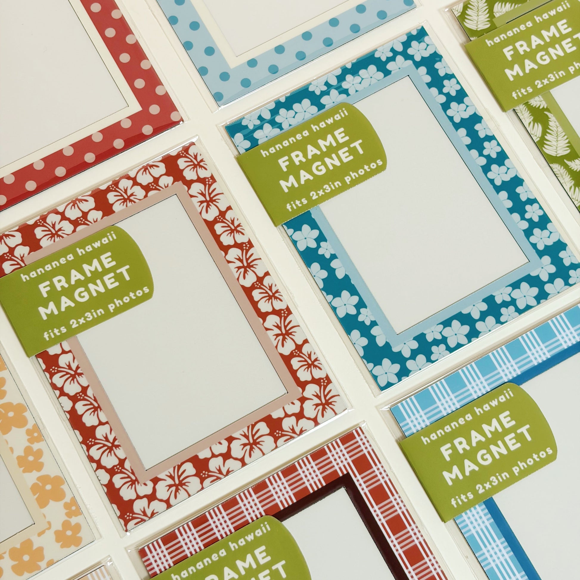 A close-up of multiple decorative frame magnets arranged on a white surface. 