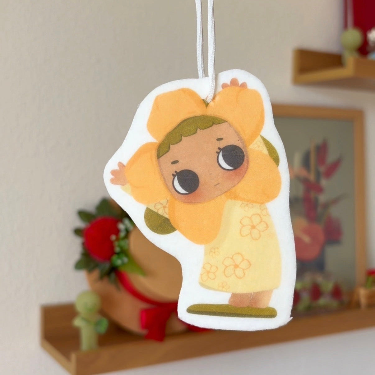 Cartoon character air freshener hanging against a neutral background