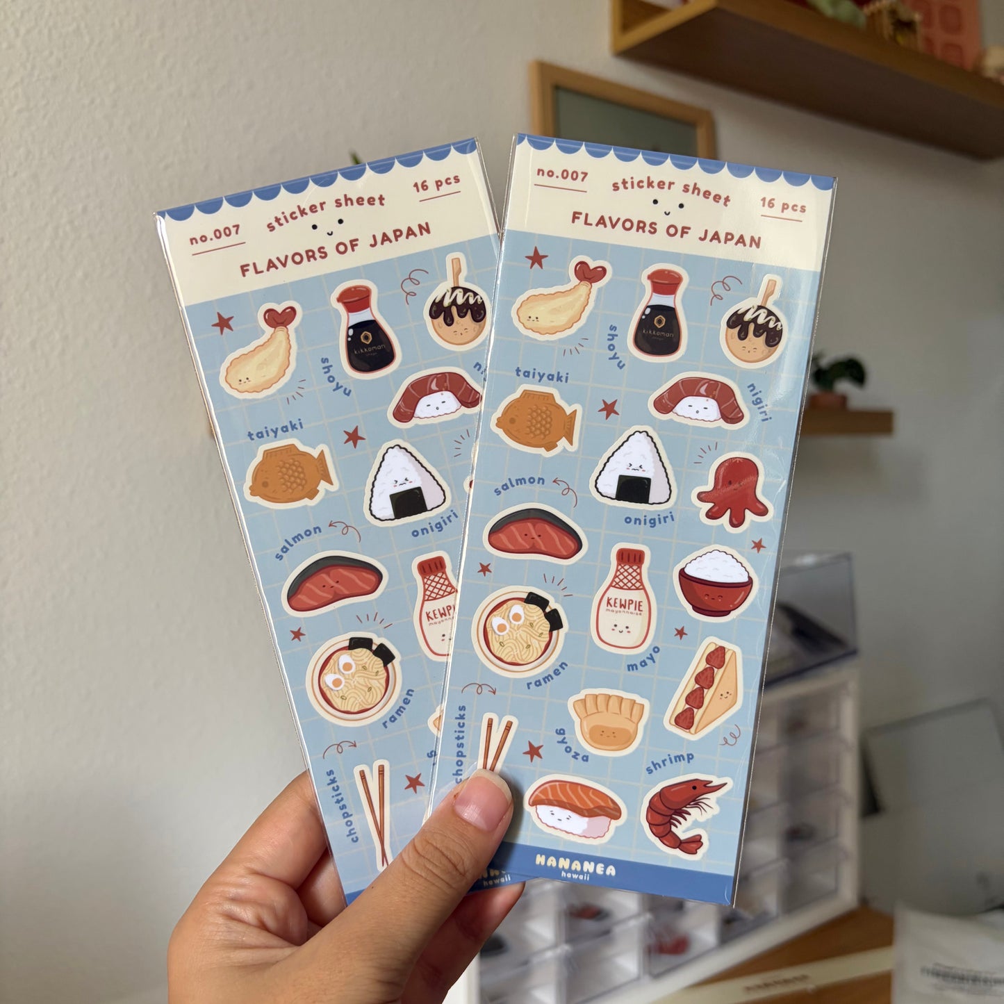 Two sticker sheets titled 'Flavors of Japan' held by a hand against a neutral background.