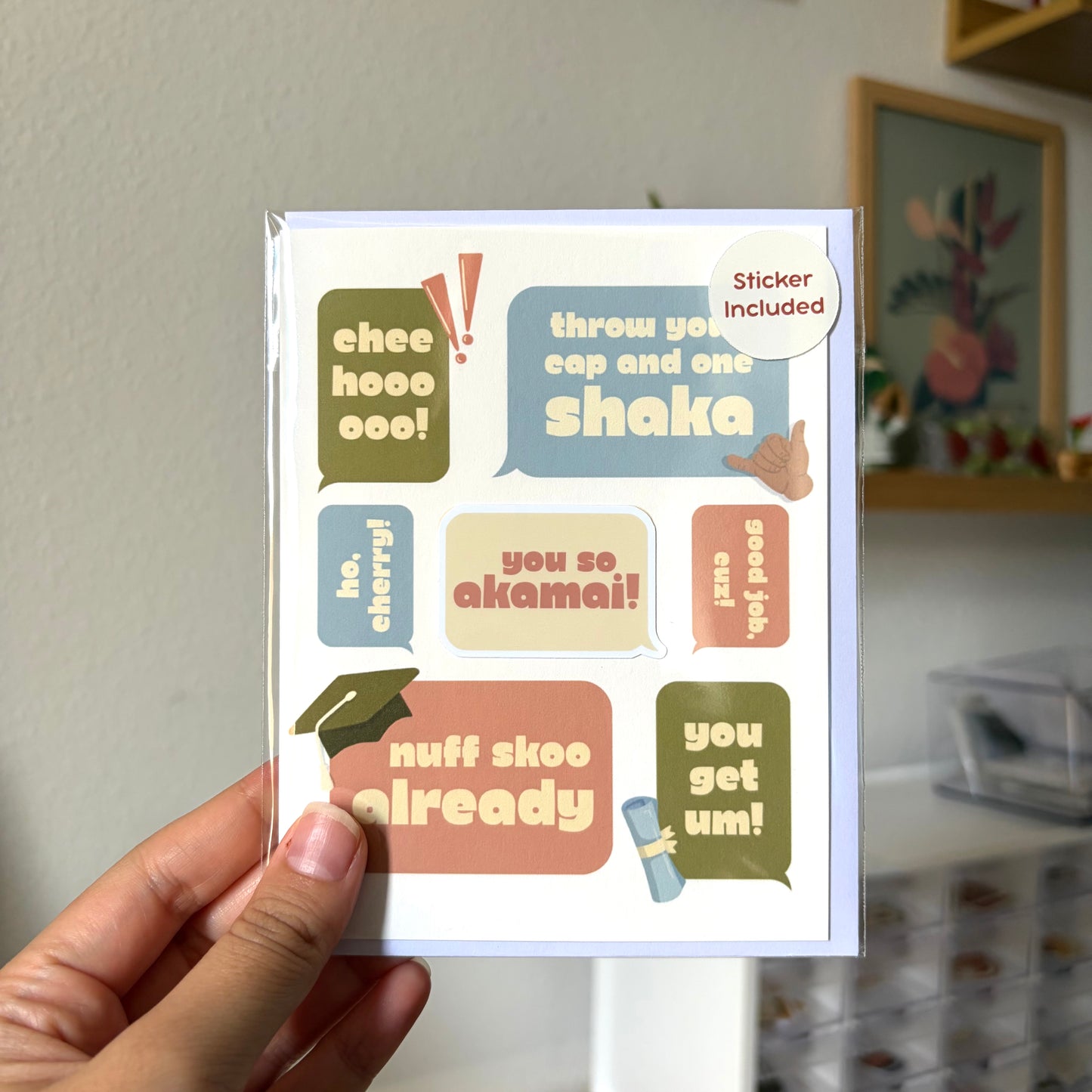 Hand holding a card with colorful text and a sticker included.