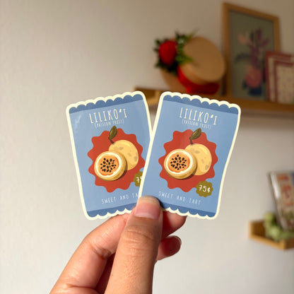 Two small cards with fruit illustrations held by a hand against a neutral background.